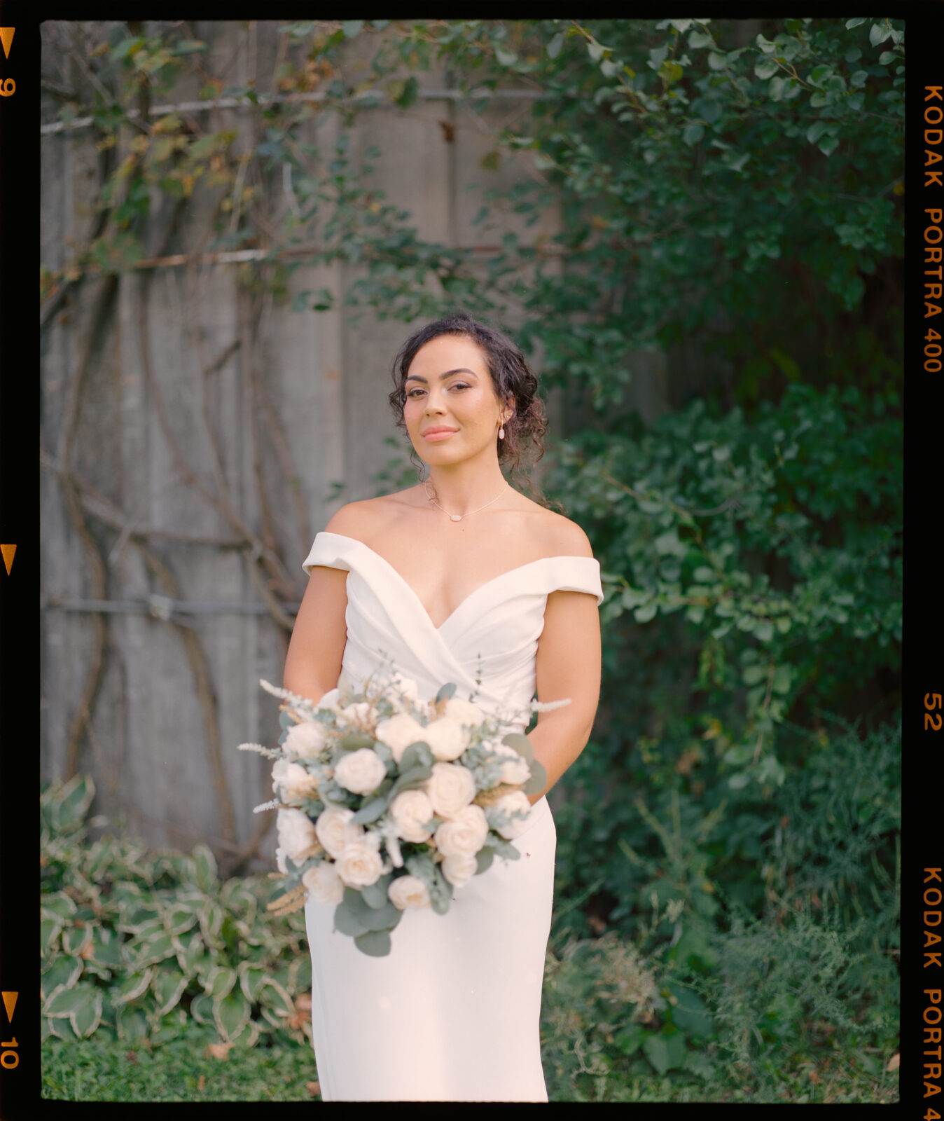 Bride standing eloquently with bokeh in her hands on film